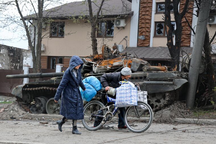 Local civilians walked past a tank destroyed during heavy fighting in an area controlled by Russian-backed separatist forces in Mariupol, Ukraine, on Tuesday.