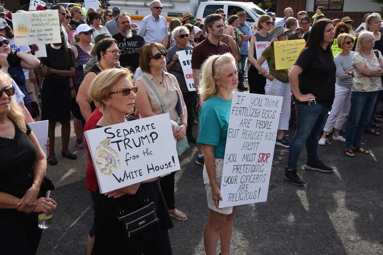 IMMIGRATION26 () / Judith Levine of Collingswood, left, and Kimberly Braunwarth, also of Colls, holding signs, among about 200 protesters gathered in Collingswood to rally against Trump's family separation policy and a Camden shelter that has entered into a $4 million federal contract to house immigrants.The event at the Groove Ground in Collingswood on Monday, June 25, 2018.