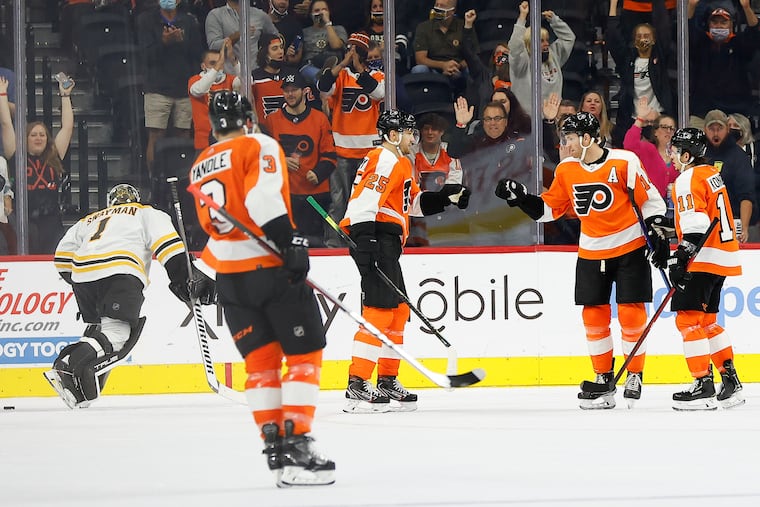 Flyers center Sean Couturier celebrates his second-period goal with left wing James van Riemsdyk (25) and right wing Travis Konecny (11).
