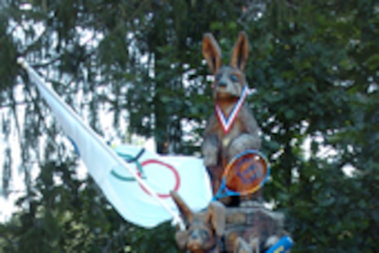 "The Bunnies" is a Marty Long wood carving. It stands on County Line Road in Villanova, and neighbors decorate it to fit the times. Here, it is adorned with Olympic doodads.