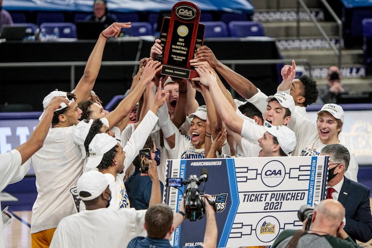 Drexel celebrates with the trophy after beating Elon in the CAA tournament championship game.