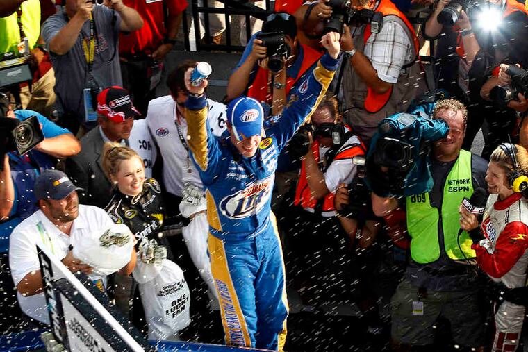 Brad Keselowski celebrates in victory lane after winning the NASCAR race at Pocono despite having to drive 500 miles with a badly broken left ankle.