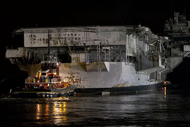 Tugboat Alex McAllister pushes the decommissioned aircraft carrier Forrestal out to Delaware River as it makes final voyage from Navy Shipyard in South Philadelphia to a dismantling and recycling facility in Brownsville, Texas. The aircraft carrier was pushed into the Delaware River early Tuesday, February 4, 2014. ( ALEJANDRO A. ALVAREZ / STAFF PHOTOGRAPHER )