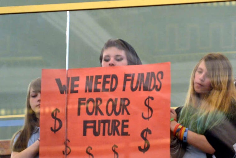 Tom Wolf has accused Gov. Tom Corbett of taking "an ax" to schools with a $1 billion cut in education dollars that caused 27,000 layoffs and big jumps in local property taxes. But did he?