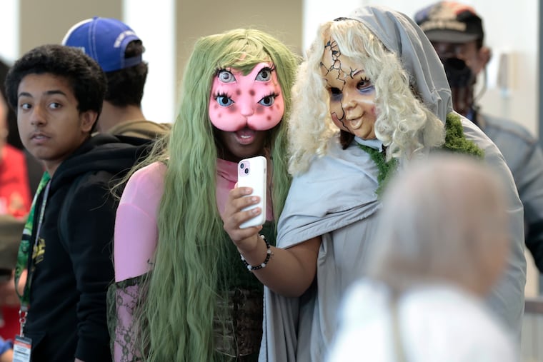 Carmelo Whitehead (center) is dressed as “Melanie Martinez” while Xavier Coles (right) is dressed as “Death”. The two Philly guys were taking a photo while waiting in line to see WWE wrestler John Cena during FAN EXPO Philadelphia 2025 at the Pennsylvania Convention Center in Philadelphia on Saturday, May 17, 2025.