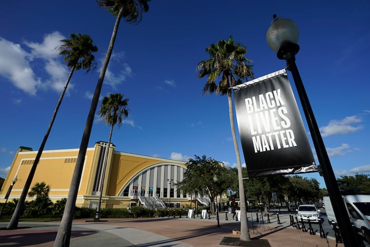 A Black Lives Matter banner hangs outside of the arena after a postponed NBA basketball first round playoff game between the Milwaukee Bucks and the Orlando Magic, Wednesday, Aug. 26, 2020, in Lake Buena Vista, Fla. The game was postponed after the Milwaukee Bucks didn't take the floor in protest against racial injustice and the shooting of Jacob Blake, a Black man, by police in Kenosha, Wisconsin.
