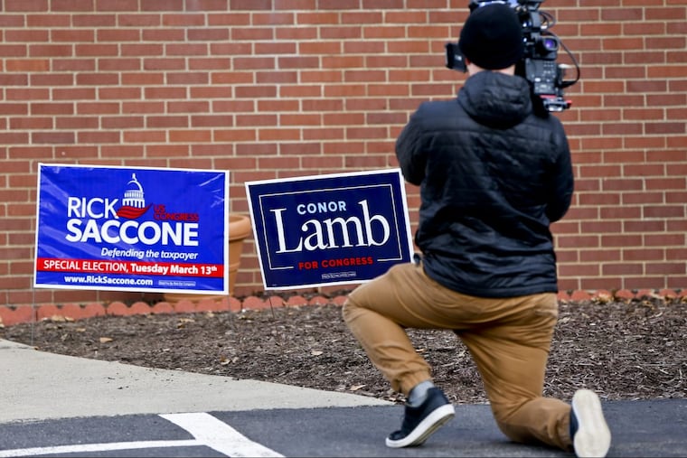 A cameraman takes footage of the signs for the candidates Rick Saccone and Conor Lamb outside a polling place in Pennsylvania’s 18th Congressional District, where a special election is being held.