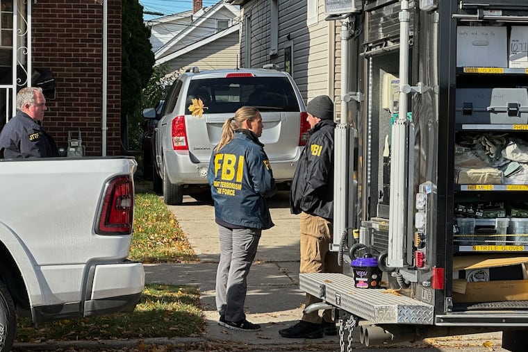 FBI agents gather outside a home in a Dearborn, Mich., neighborhood on Friday, Oct. 31, 2025.