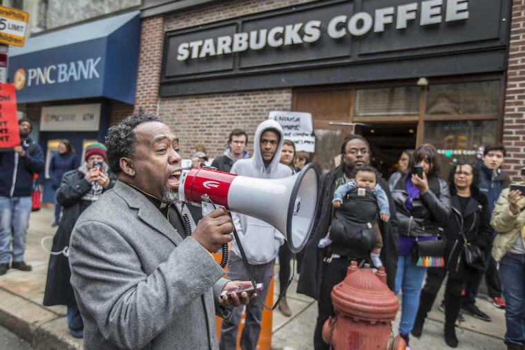 Rev. Jeffrey Jordan uses a bullhorn to get the crowd of protesters in front of the Starbucks at 18th and Spruce, to yell "I am somebody," on April 15, 2018, in protest to the two black men arrested there three days earlier.