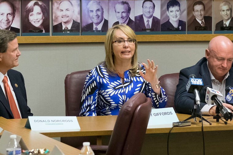 Former Arizona Rep. Gabby Giffords , who survived a shooting in 2011, with her husband, former astronaut Mark Kelly (right), and New Jersey Democratic Rep. Donald Norcross at a November 2018 gathering in Cherry Hill. ED HILLE / Staff Photographer