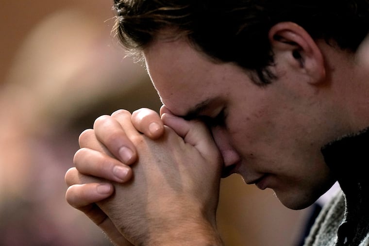 FILE - A man prays during Catholic Mass at Benedictine College, Oct. 29, 2023, in Atchison, Kan.