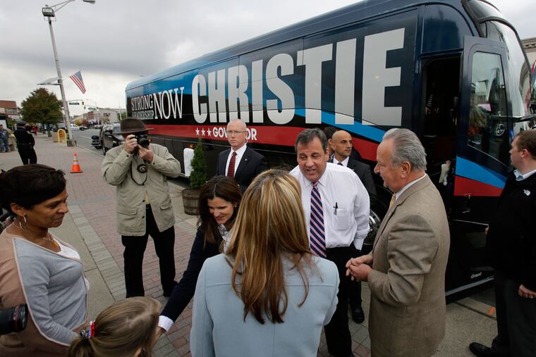 Gov. Christie greets well-wishers in Linden, including Mayor Richard J. Gerbounka (second from right), on a late-campaign bus trip. Polls suggest Christie will win reelection in a landslide over Democrat Barbara Buono on Tuesday.