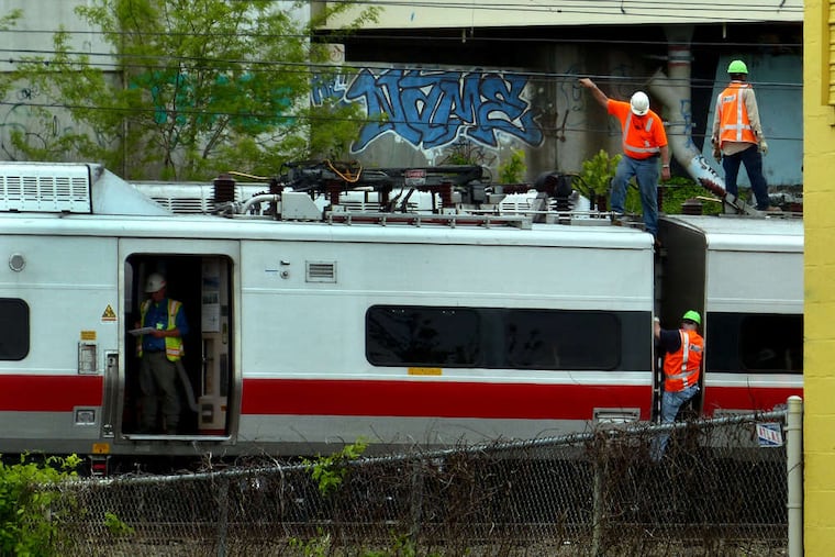 Metro-North Railroad employees work at the scene of the train derailment and crash in Bridgeport, Conn.