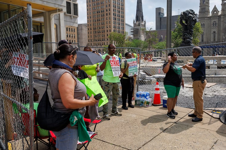At right is a Philadelphia Police Civil Affairs officer at the picket line outside the Municipal Services Building on the first day of strike by the municipal workers in AFSCME District Council 33, Tuesday, July 1, 2025.