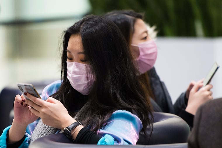 People wear masks following the outbreak of a new virus as people arrive from the International terminal at Toronto Pearson International Airport in Toronto on Saturday, Jan. 25, 2020.