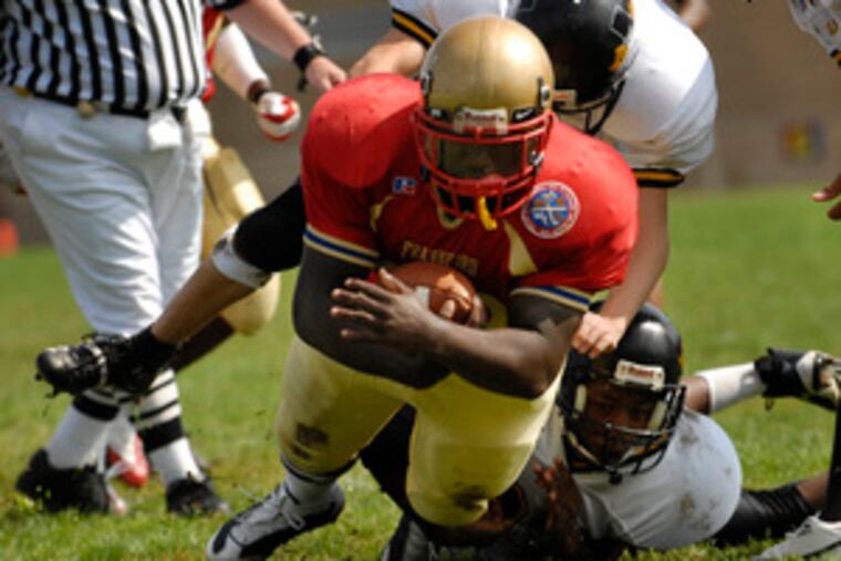 There was a game played yesterday, too. Frankford's Terrell Lewis finds a hole in the Lincoln line and squirts through for some yardage. A famous Frankford back was there for the 33-0 win - Blair Thomas, who played in the NFL.