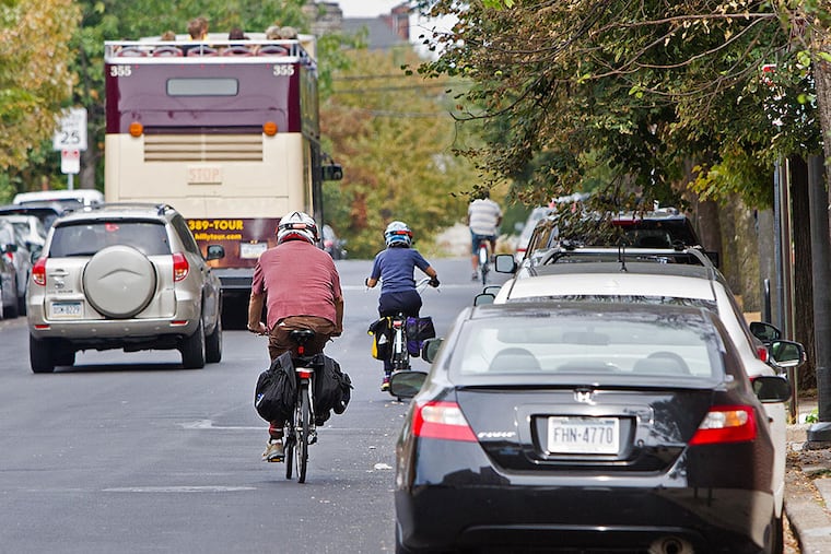 With no bike lane on 22d Street, bicyclists navigate traffic and parked cars. (DAVID M WARREN / Staff Photographer)