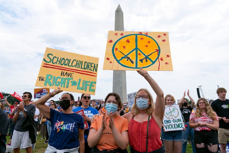 People hold signs in the second March for Our Lives rally in support of gun control in front of the Washington Monument, Saturday, June 11, in Washington.