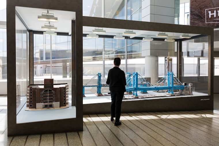 A traveler looks at Kambel Smith's cardboard sculptures, which are now on display in terminal A at Philadelphia International Airport.