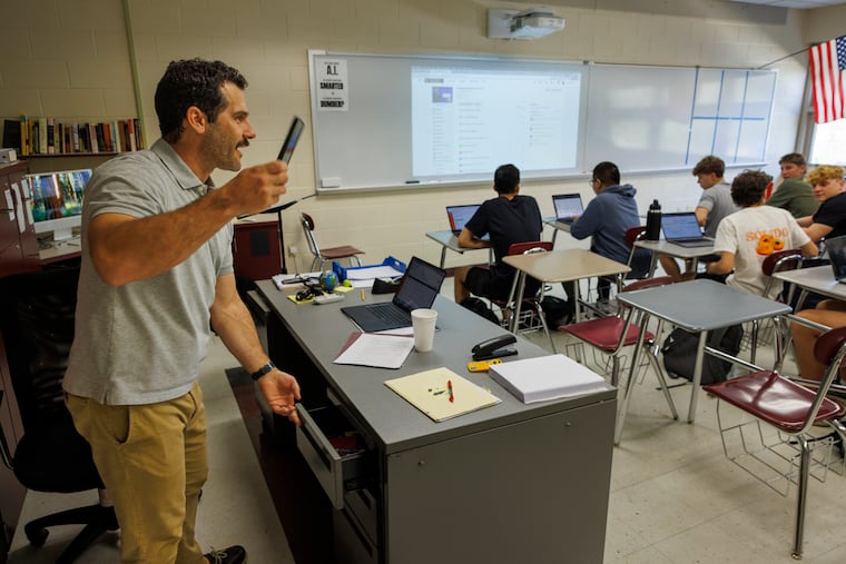 Marc Panepinto, a social studies teacher at Garnet Valley High School, reminds students to put away their phones as he puts away his own at the start of a class last week.