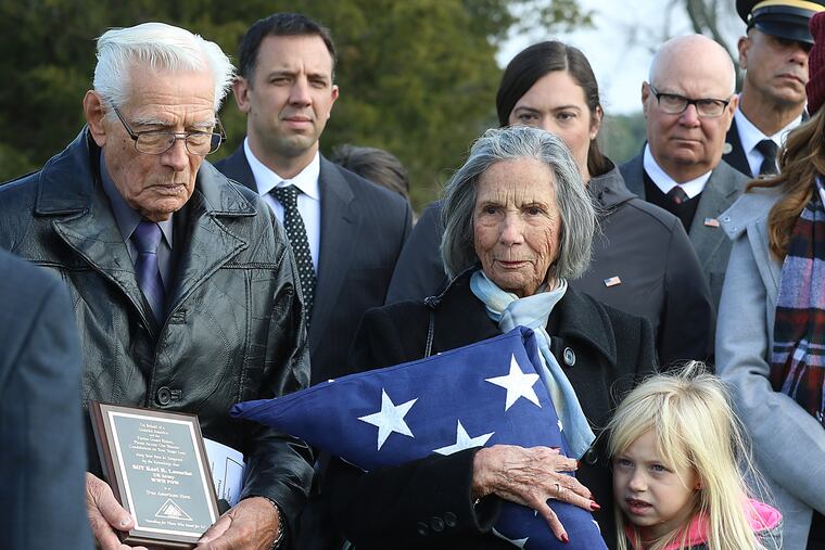 Listening to Taps being played at the conclusion of services for their brother, Army Sgt. Karl R. Loesche, are (left) Richard Loesche, of Florida, and Marion Atkinson, of Bensalem, Pa.. Her great-grandaughter, Marin VanGilder, 8, is at her side. The remains of Sgt. Loesche, who perished in a POW camp in 1942, had been interred as unidentified in a military cemetery in the Philippines until a DNA match with his last two surviving siblings was made three months ago.