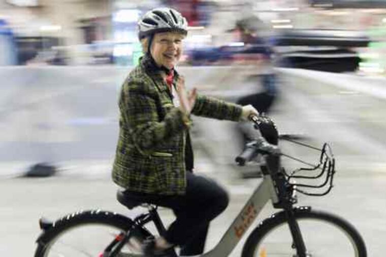 Colette Obre takes a spin on a public bicycle in Montreal. Locally, Philadelphia will open two cross-town bicycle paths today.