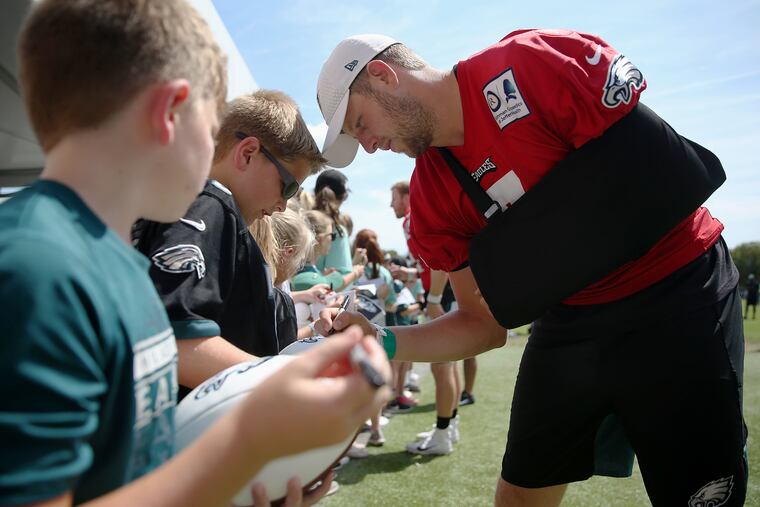 Injured backup quarterback Nate Sudfeld, right, signs an autograph for Will Whitmore, 12, of Chester Springs, Pa., after Eagles training camp at the NovaCare Complex in South Philadelphia on Saturday, Aug. 10, 2019.