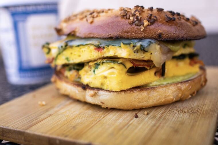 Frittata sandwich at Pivot has eggs. spinach, roasted red pepper, sharp Cheddar, and poblano aioli on a garlic bagel.