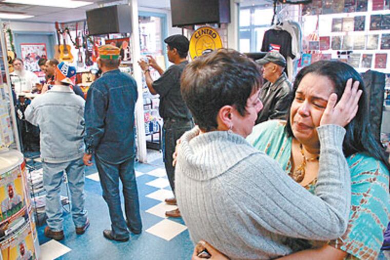 Cristina Gonzalez (left), wipes tears from the face of Racheal Rojas at a musical tribute to their friend Joaquin Rivera, who died while waiting for treatment in the emergency room of Aria Frankford Torresdale Hospital and was subsequently robbed. (Clem Murray / Staff Photographer)