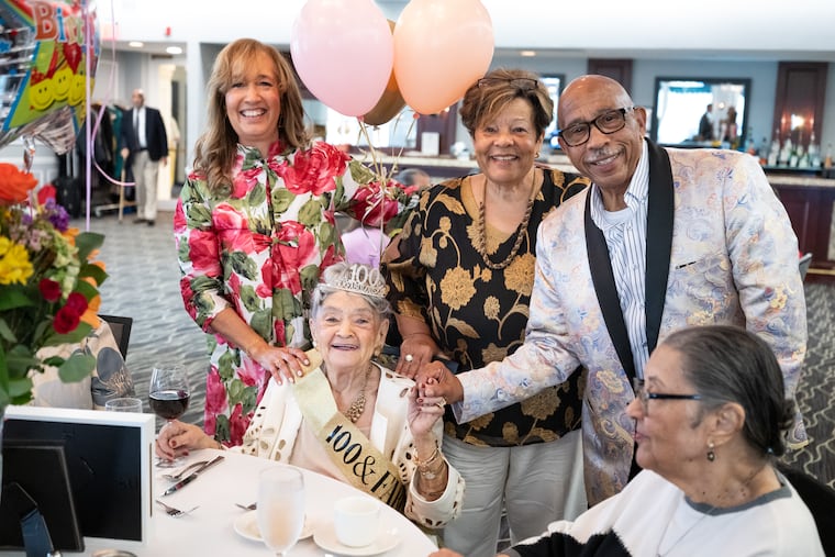 (From left) Carolie Barksdale, Pamela Norris, and Anthony Alleyne pose with Wiladine Bain at her 100th birthday celebration at North Hills Country Club in Glenside, Pa., on Saturday, May 23, 2026. Barksdale is Bain’s daughter, and Norris is her goddaughter.