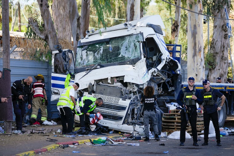 Israeli police and rescue services inspect the site where a truck driver rammed into a bus stop near the headquarters of Israel's Mossad spy agency, wounding dozens of people, according to Israel's Magen David Adom rescue service in Tel Aviv, Israel, Sunday.