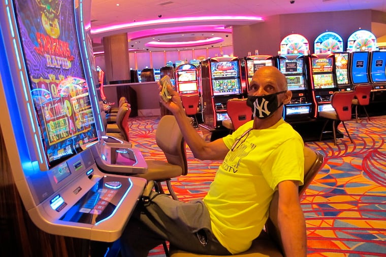 Gary Royster of Atlantic City holds up cash he used to gamble at the Hard Rock casino in Atlantic City on July 2, 2020, the day the casino reopened after being shut down for months amid the coronavirus outbreak. How quickly Atlantic City bounces back in 2021 will depend in large part on how quickly the coronavirus pandemic is brought under control in the new year. (AP Photo/Wayne Parry)