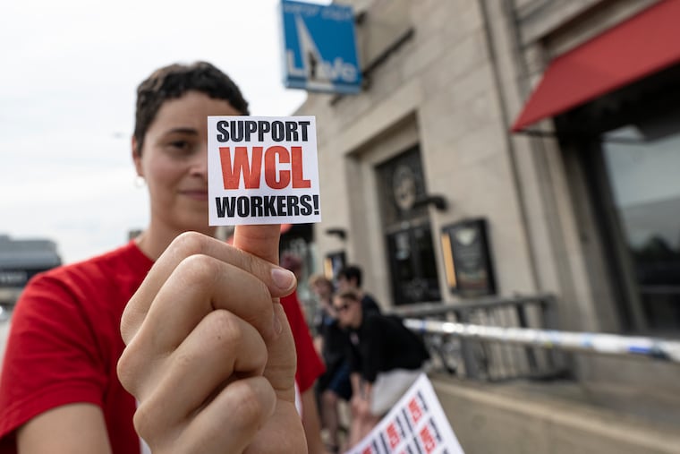 Union rep Kerrick Edwards shows a support sticker outside the World Cafe Live building on Thursday, July, 2025. A Town Hall meeting took place at the World Cafe Live, which has been in turmoil since workers walked out during a show last month.
