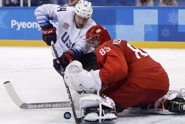Broc Little (14), of the United States, and Russian goalie Vasili Koshechkin battle for the puck during the third period of a preliminary round game. The United States has just four goals in three games.