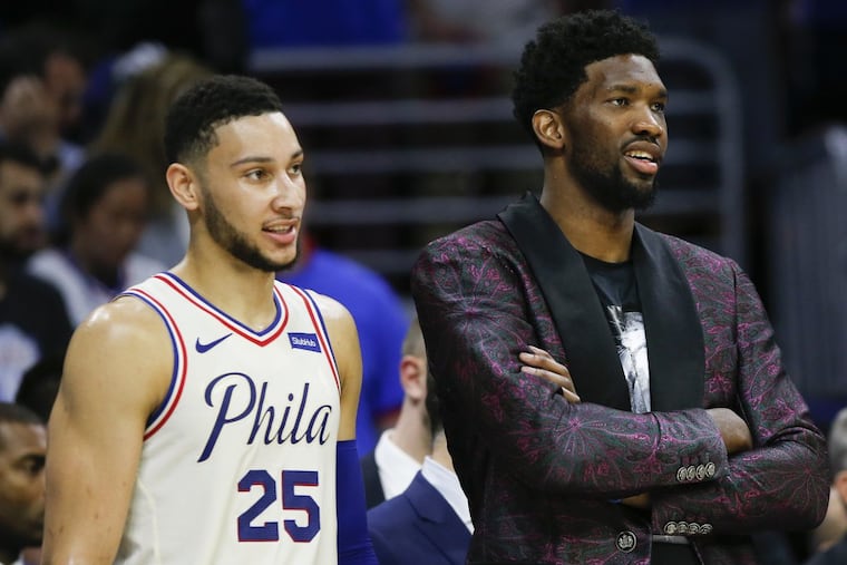 Sixers center Joel Embiid with teammate guard Ben Simmons watched the end of game one against the Heat during the Eastern Conference quarterfinals on Saturday.