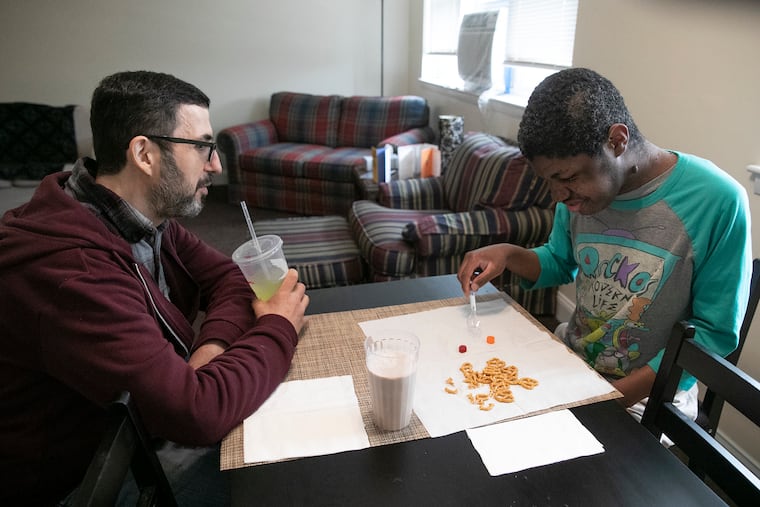 Bob Reiss (left) and Benjamin Tucker chat at the kitchen table during Benjamin’s afternoon snack at the home they share.