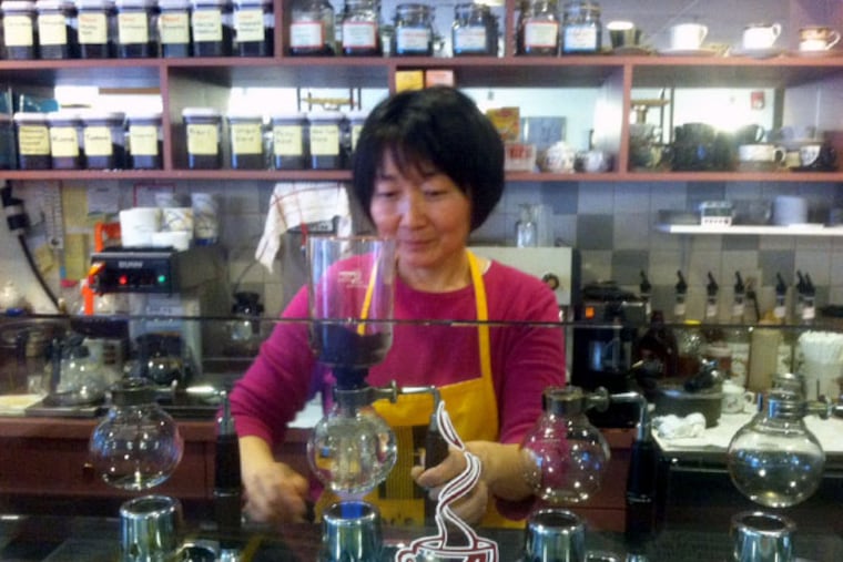 Chen, owner of Ray's, prepares a special brew using the cafe's siphon system.