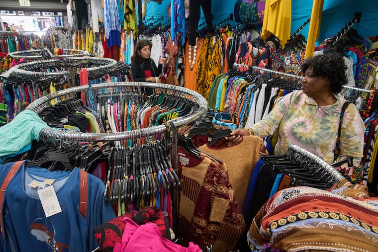 Business owner Asha Sham (left) assists a wholesale client, fashion designer Diana Axtell, with purchasing African-imported clothing wholesale in Los Angeles in 2025. Trump administration policies are causing unease among U.S. businesses that trade with African nations, writes Alexanderia Haidara.