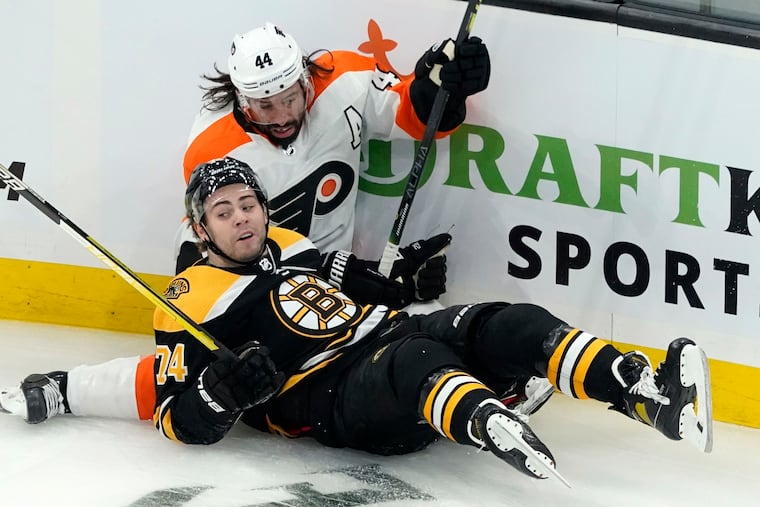 Boston Bruins left winger Jake DeBrusk and the Flyers' Nate Thompson crash along the boards in the first period of Boston's 4-2 preseason win on Thursday night.
