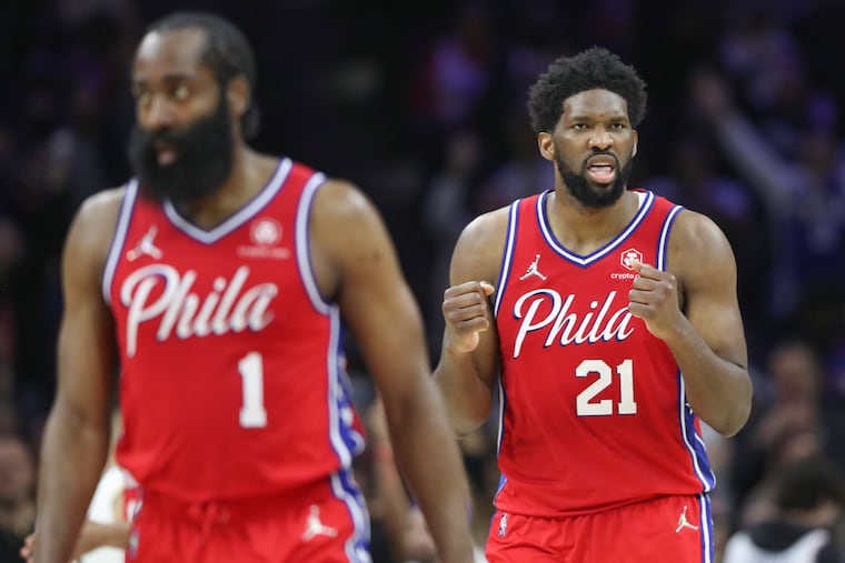 Sixers center Joel Embiid (21) celebrates behind guard James Harden (1) after a Danny Green four-point play in the fourth quarter of a game against the Indiana Pacers at the Wells Fargo Center on Saturday.