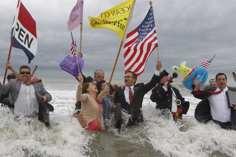 At Ocean City's Moorlyn Terrace beach , a group in business suits with attache cases marches in the surf to the strains of "Pomp and Circumstance." There were celebrations of the new tourism season up and down the Jersey Shore. AKIRA SUWA / Staff Photographer