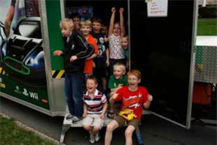 Rolling Game Station, a 32-foot trailer loaded with video games, went to Zachary Jordan's house in Douglassville for his eighth-birthday party. It is one of at least five games on wheels operations in the area. (Michael S. Wirtz / Staff Photographer)
