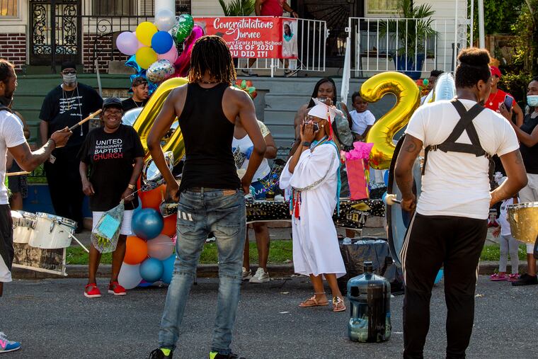 Jurnee Jenkins, 18, is surprised by a drum line as family and friends hold a drive-by graduation celebration outside her home on North Sixth St. in Olney on June 9, 2020.