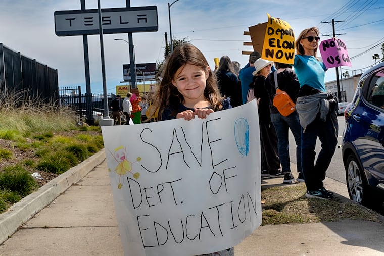 Sarah Cummings carries a protest sign to save the Department of Education while joining other protesters outside a Tesla showroom and service center in the North Hollywood section of Los Angeles on March 15.