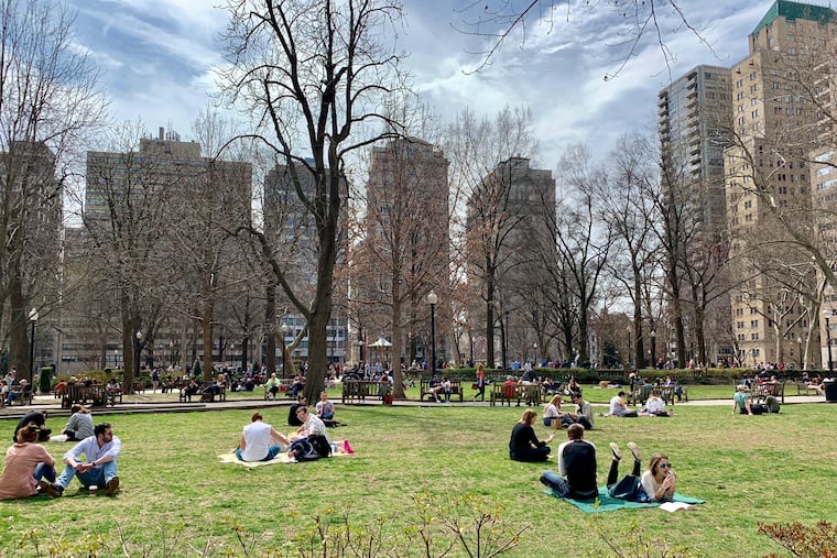 Philadelphia residents sprawl on the grass of Rittenhouse Square on a balmy March afternoon. The park is one of five original squares planned by William Penn in the late 17th century.