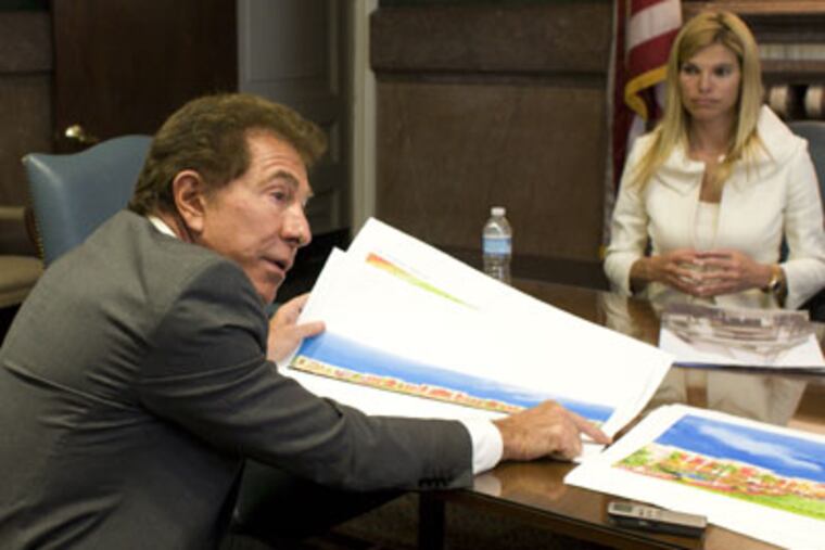 Steve Wynn spreads out color renderings of his plans for the remade Foxwoods Casino in Pennsport. His girlfriend Andrea Hissom looks on. (Ed Hille / Staff Photographer)