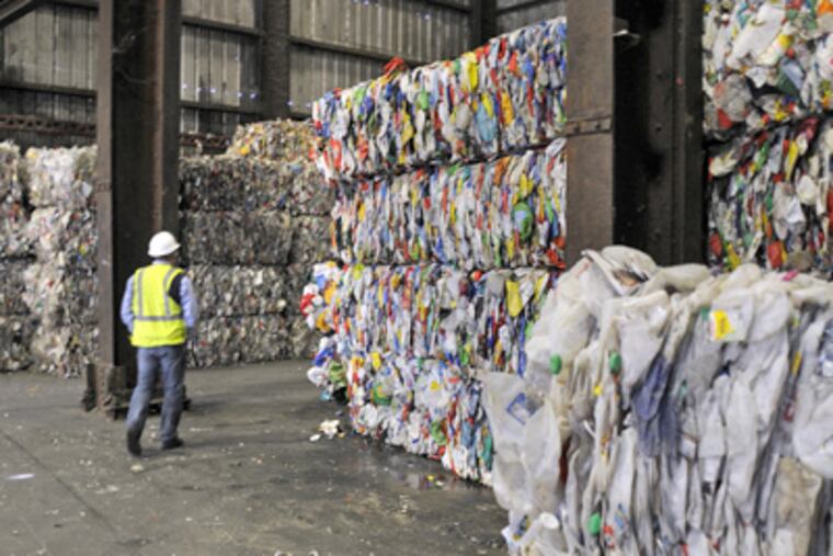 Michael McQuade of ReCommunity passes through bundles of sorted plastic at the company's Camden recycling plant. (Tom Gralish / Staff Photographer)