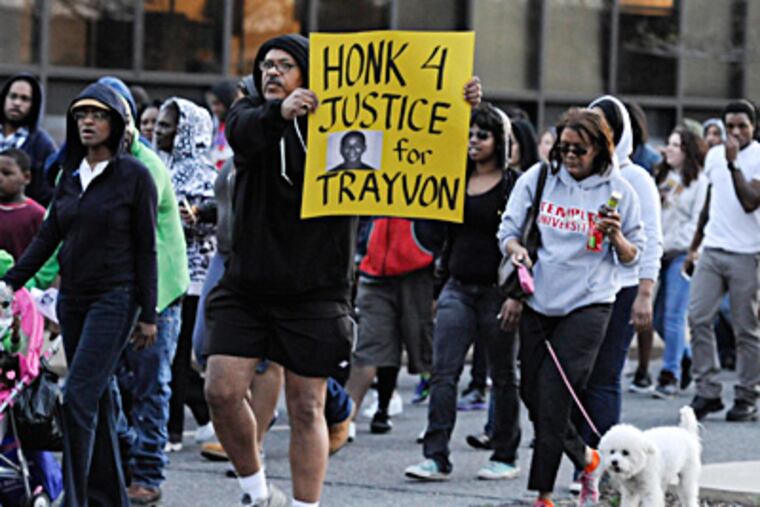 A man prompts drivers to honk their car horns as protesters march along JFK Boulevard to a rally for slain Florida teen Trayvon Martin. RON TARVER / Staff Photographer