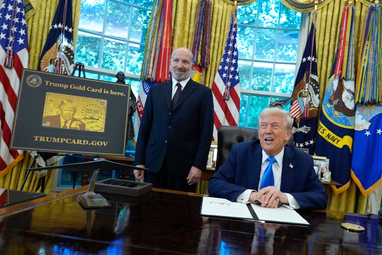 President Donald Trump speaks as Commerce Secretary Howard Lutnick listens alongside a poster of the Trump Gold Card in the Oval Office of the White House, Friday, Sept. 19, 2025, in Washington.