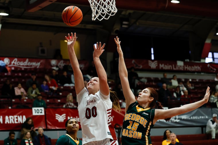 St. Joseph's Faith Stinson lays up the ball past George Mason forward Louis Volker during the first quarter Sunday.